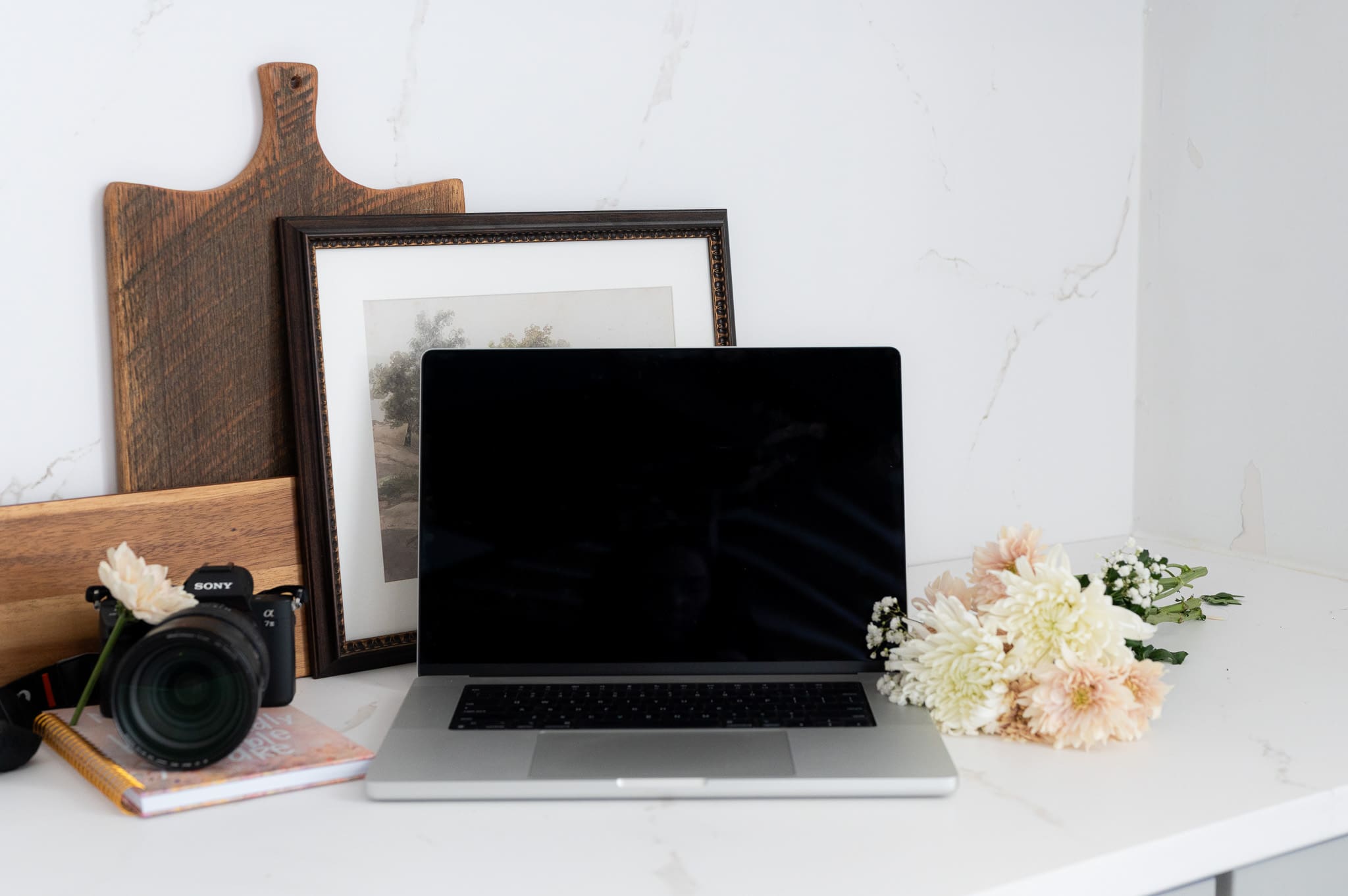 an image of a camera, a laptop and flowers sitting on a desk text overlay says blogging for SEO